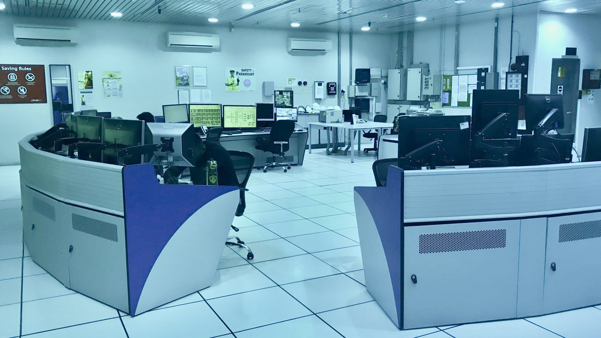 Bir su arıtma tesisinin SCADA kontrol odasında monitörlerle donatılmış boş operatör konsolları