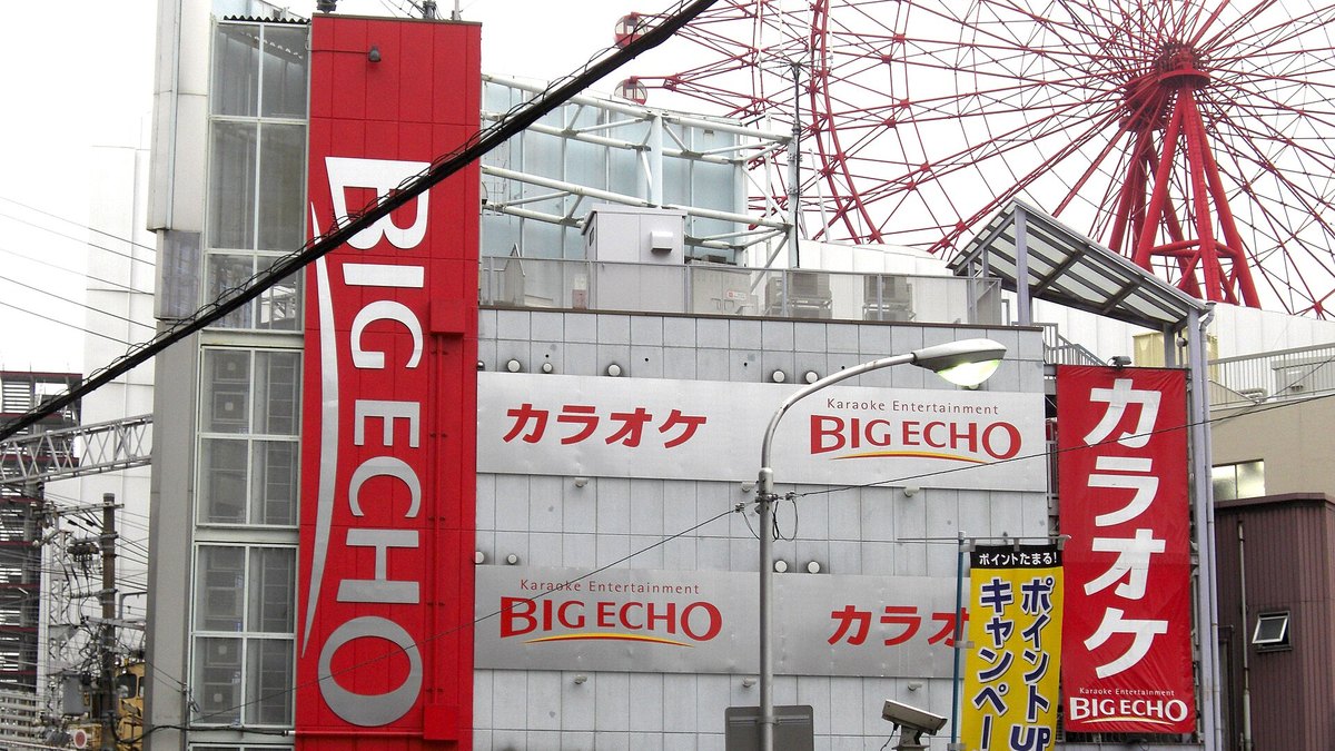 Osaka'daki bir Big Echo karaoke şubesinin cephesi; kırmızı dikey BIG ECHO tabelası ve Japonca karaoke panoları — temsili fotoğraf
