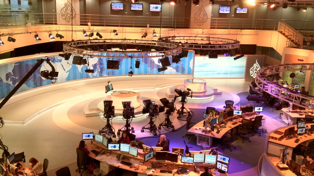 Al Jazeera English haber merkezi, logolu stüdyo ve haber masaları (temsili; olay görüntüsü değil)