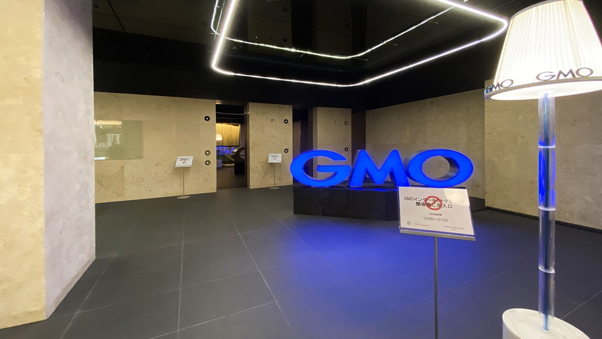 Tokyo'daki GMO Internet Group ofis lobisinde mavi ışıklı büyük GMO logosu
