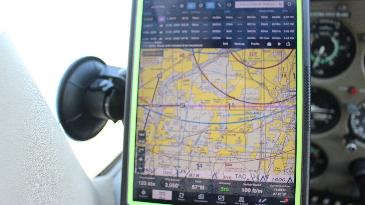 Küçük bir uçağın kokpitinde vantuzlu tutucuya takılı iPad'de havacılık haritası gösteren elektronik uçuş çantası uygulaması