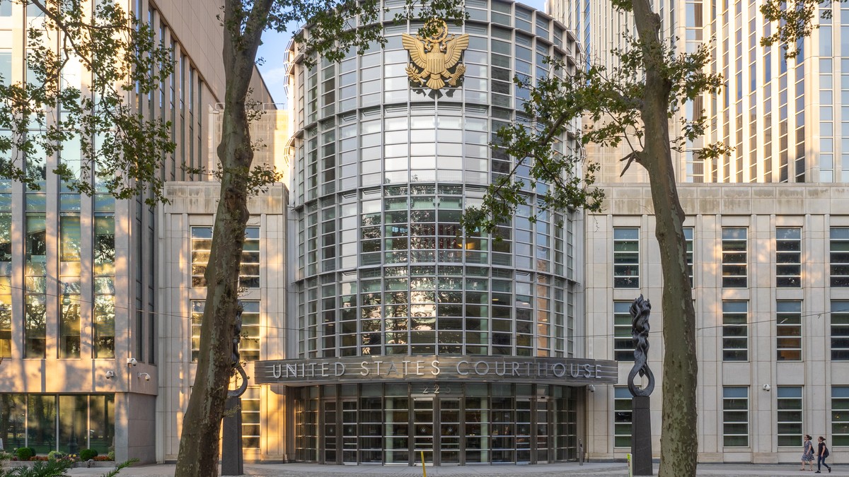 Brooklyn'deki Theodore Roosevelt ABD Adliyesi'nin cam silindir girişi, üstte ABD arması ve girişte «United States Courthouse» tabelası