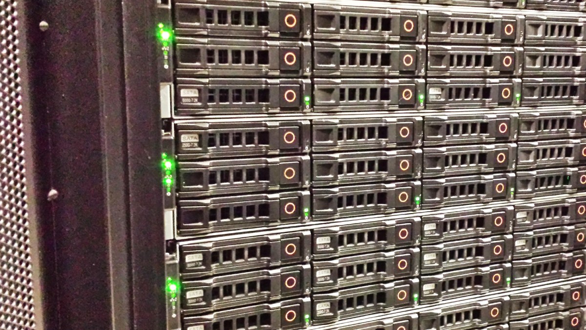 Bir veri merkezinde yeşil durum ışıkları yanan sunucu rafı ve disk yuvaları; Nvidia ya da Brev altyapısı değildir, temsili fotoğraf