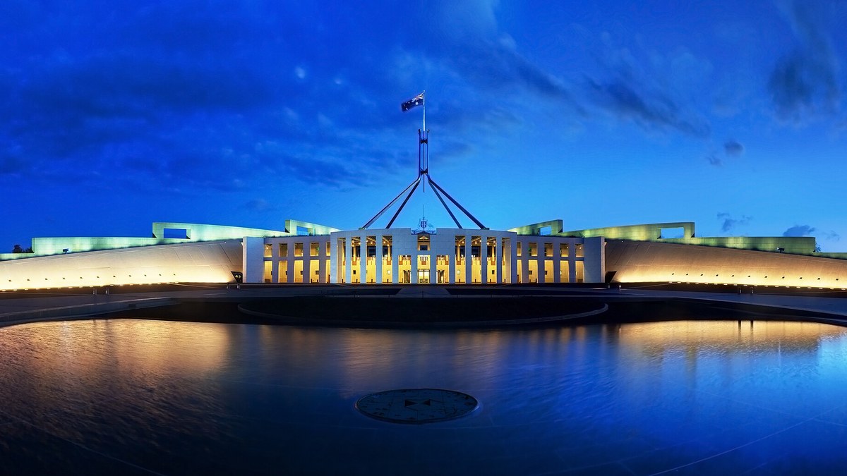 Alacakaranlıkta ışıklandırılmış Avustralya Parlamento Binası ve bayrak direği, Canberra (temsili)