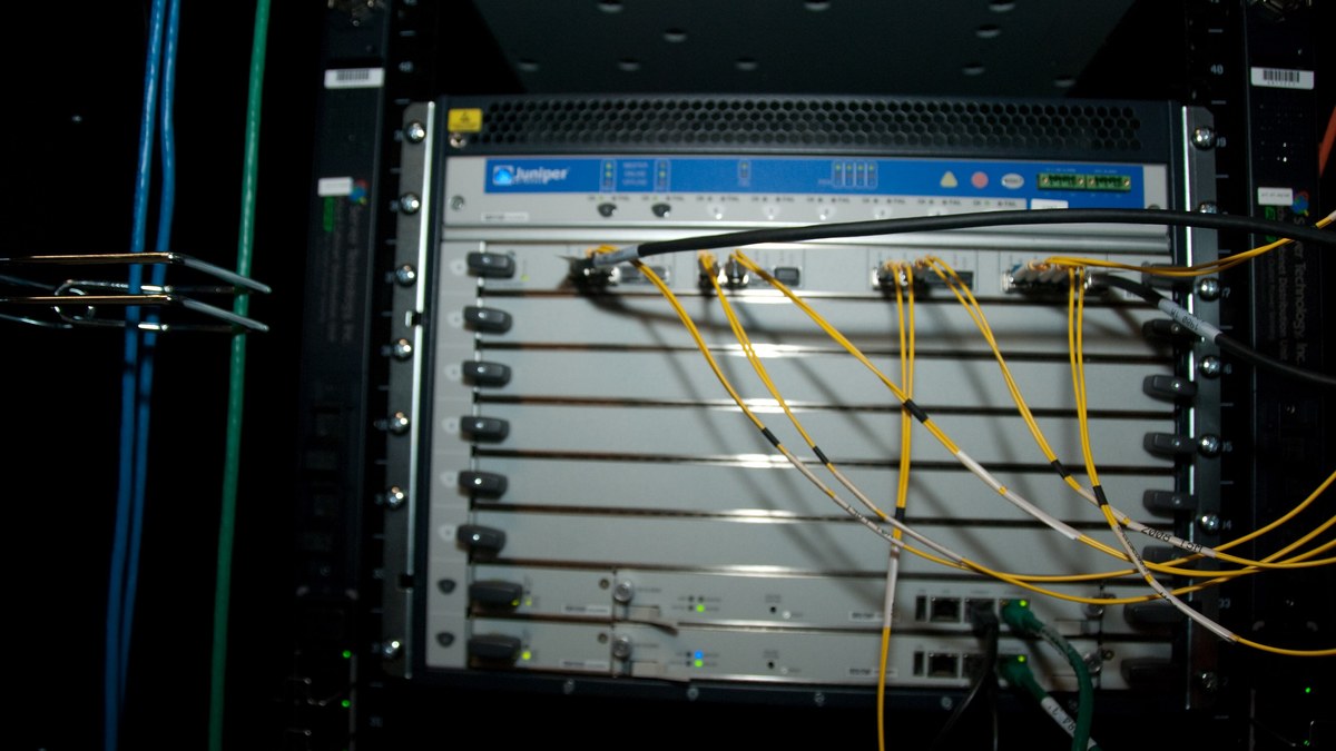 Veri merkezi kabininde fiber kablolu Juniper yönlendirici şasisi (temsili)