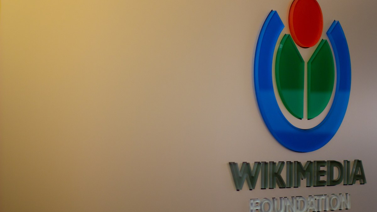San Francisco'daki Wikimedia Vakfı merkezinde duvardaki mavi, yeşil ve kırmızı Wikimedia logosu ve altında Wikimedia Foundation yazısı